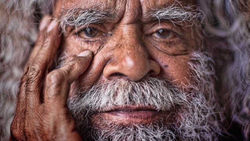An extreme close-up of Uncle Jack Charles' holding his hand to his face.