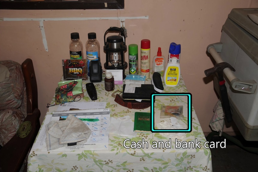 a table with cash, cards, a calendar and insect repellent