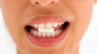 Woman with medicine in mouth (Thinkstock: Pixland)