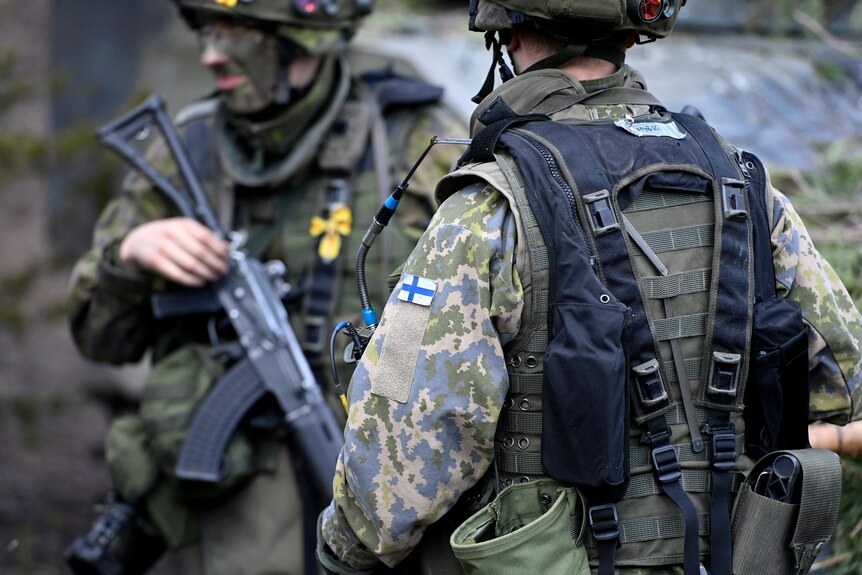 Finnish soldiers holding rifles take part in the Army mechanised exercise.