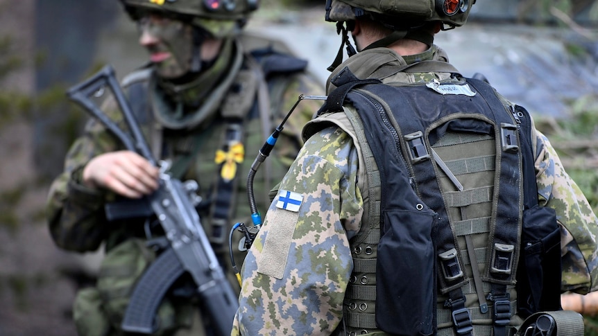 Finnish soldiers holding rifles take part in the Army mechanised exercise.