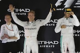 On top of the world ... Nico Rosberg (L) celebrates in Abu Dhabi, as Mercedes team-mates Lewis Hamilton looks on