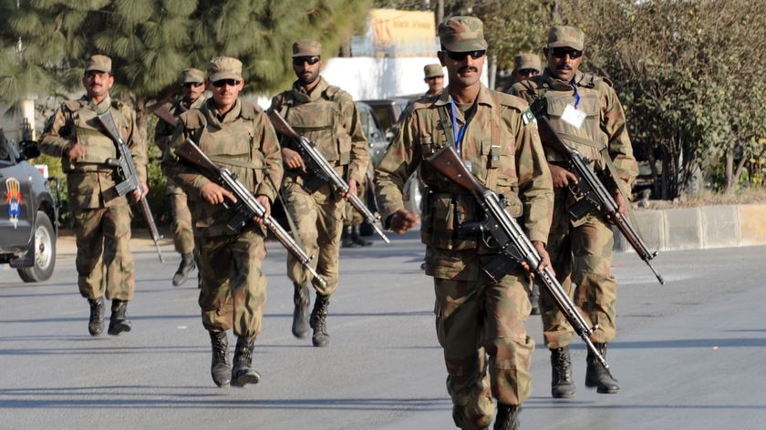 Pakistani soldiers take up position outside a besieged mosque