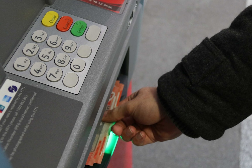 Man takes cash from ATM