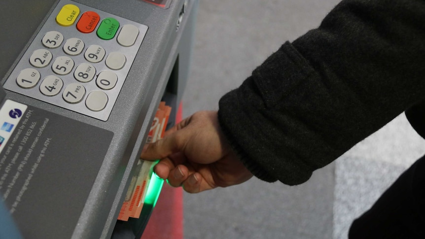 Man takes cash from ATM