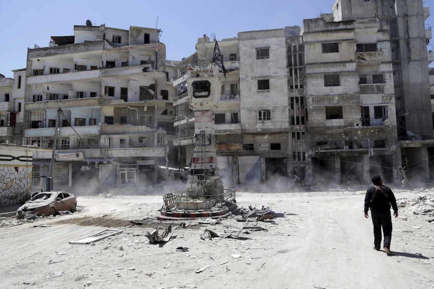 A rebel fight inspects a site damaged by Syrian air strikes