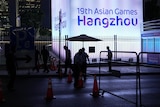 Sign reading "19th Asian Games Hangzhou" lit up at night