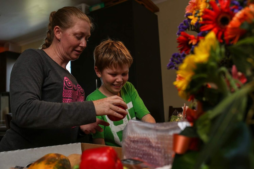 Mandy Hodges and her son Ethan rifling through food that was dumpster dived the night before