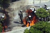 Police hit by petrol bombs thrown by protesters in front of the Greek parliament.