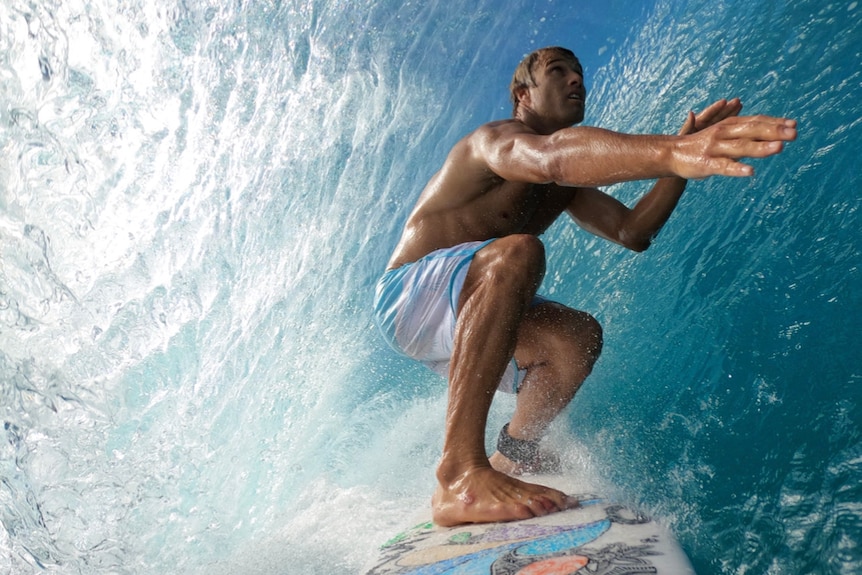 Camera shot front nose of surfboard with man in barrel of wave