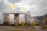 Firefighters spraying a structure with a hose