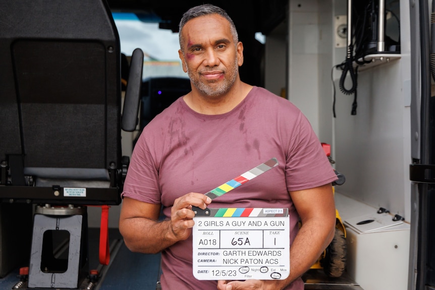 Man standing with a movie clapper board