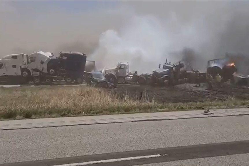 Smoking vehicles are seen after a major crash on a US highway.