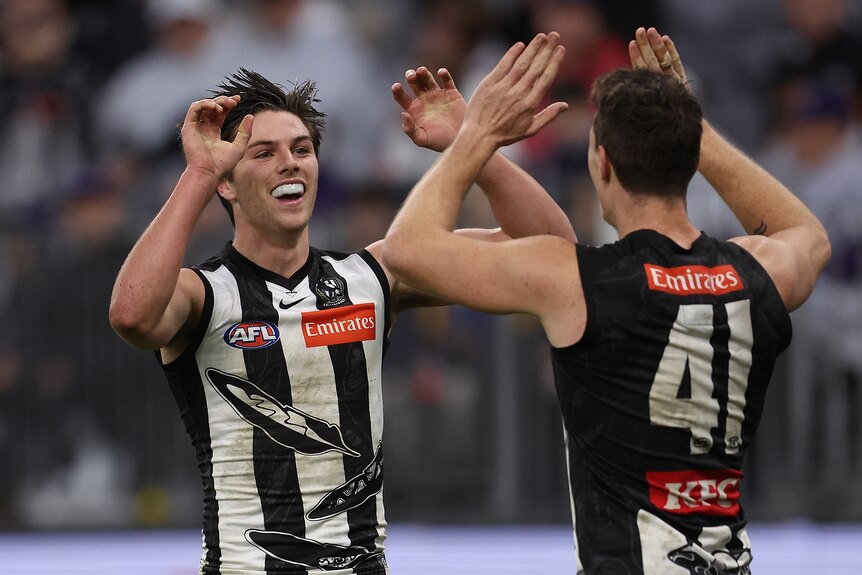 Oliver Henry high fives a teammate with a smile on his face