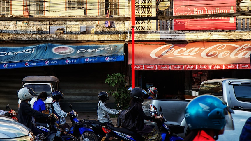 Motorcycles and cars queue in traffic in Laos 