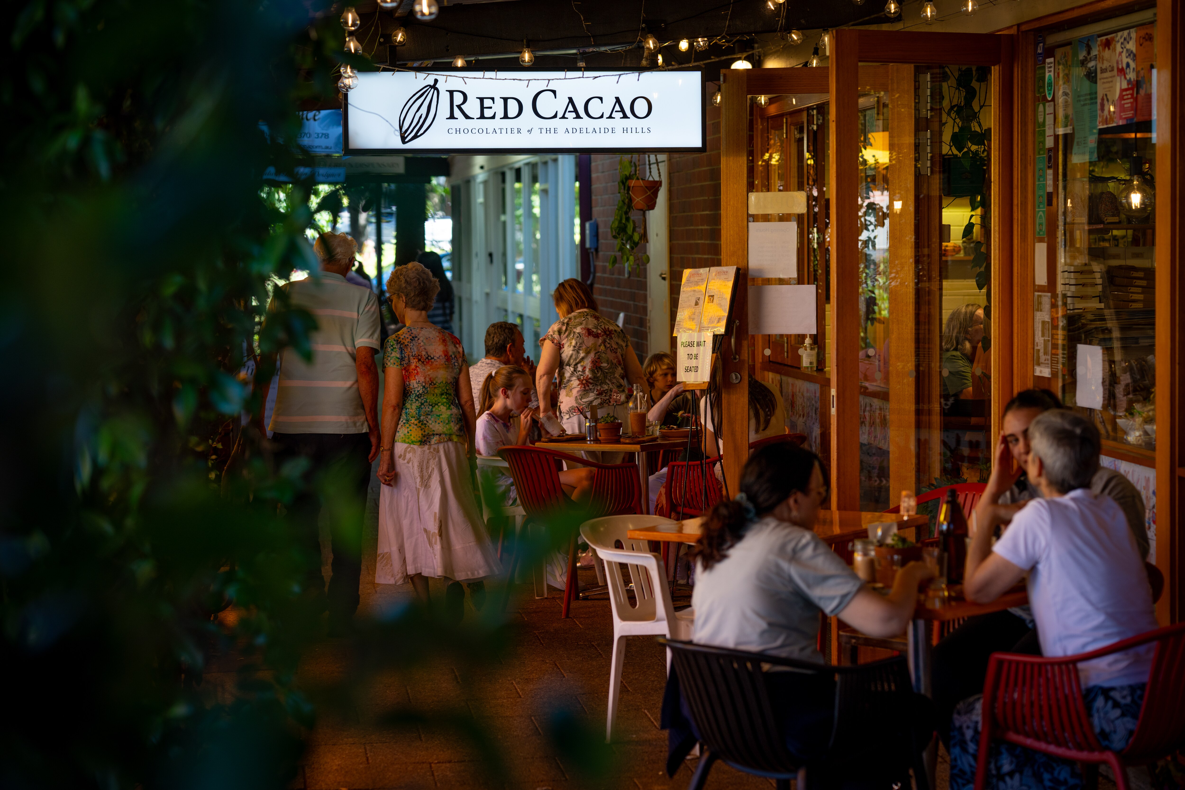 Gente apareando fuera de un café con asientos al aire libre