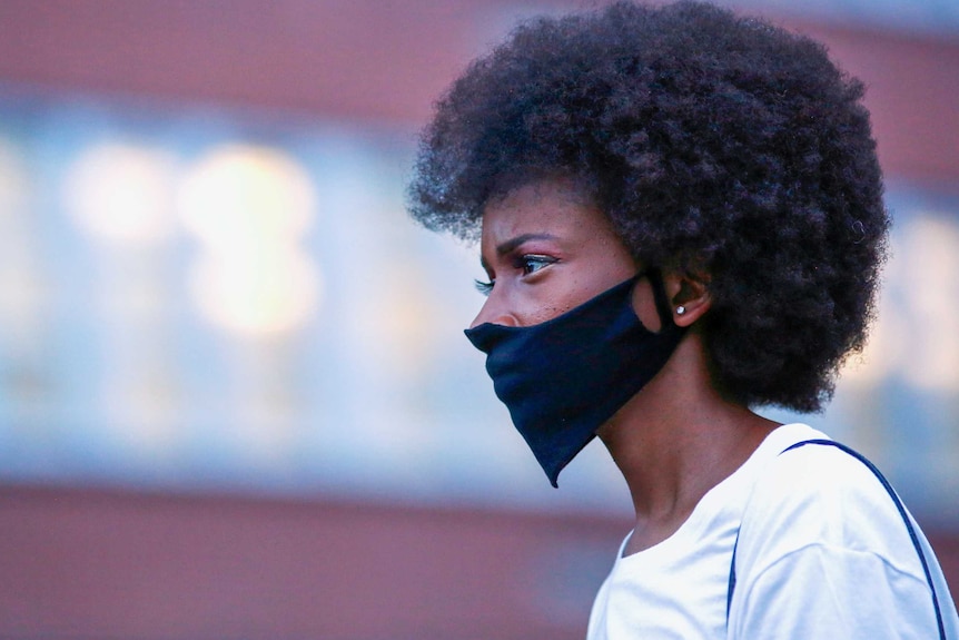 A young black woman in a face mask