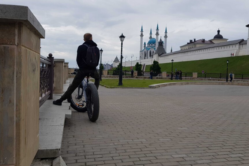 A man rides a bike with wide wheels in Russia.