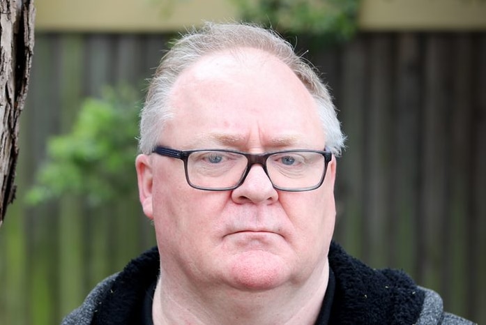 Child sexual abuse survivor Steve Fisher stands next to a tree