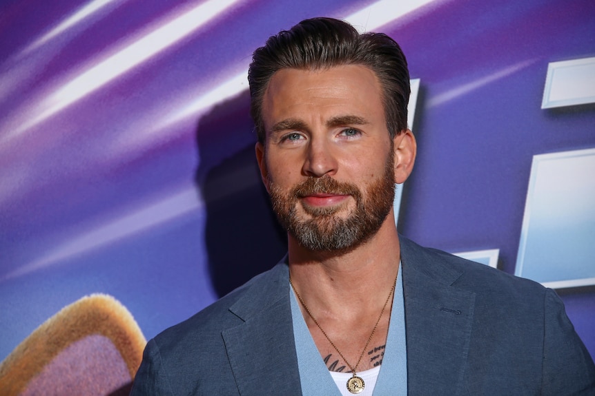 A man in a suit smiles on the red-carpet