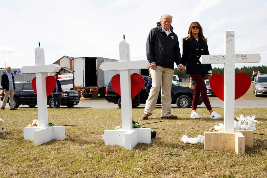 US President Donald Trump and first lady Melania Trump look at crosses marking those killed in a tornado in Alabama.