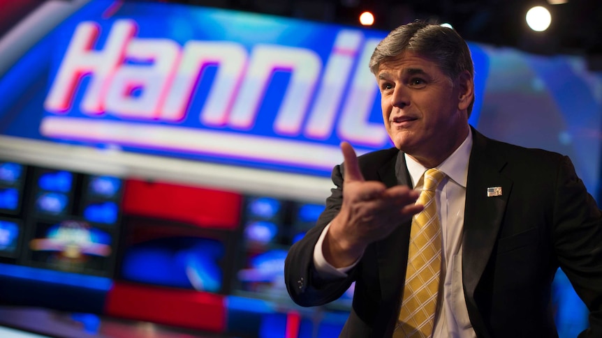 Fox News Channel anchor Sean Hannity poses for photographs as he sits on the set of his show "Hannity".