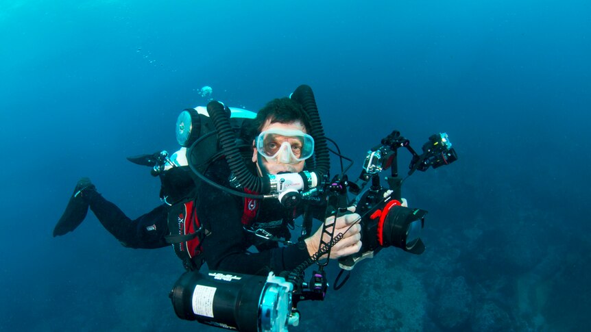 A man scuba diving with cameras