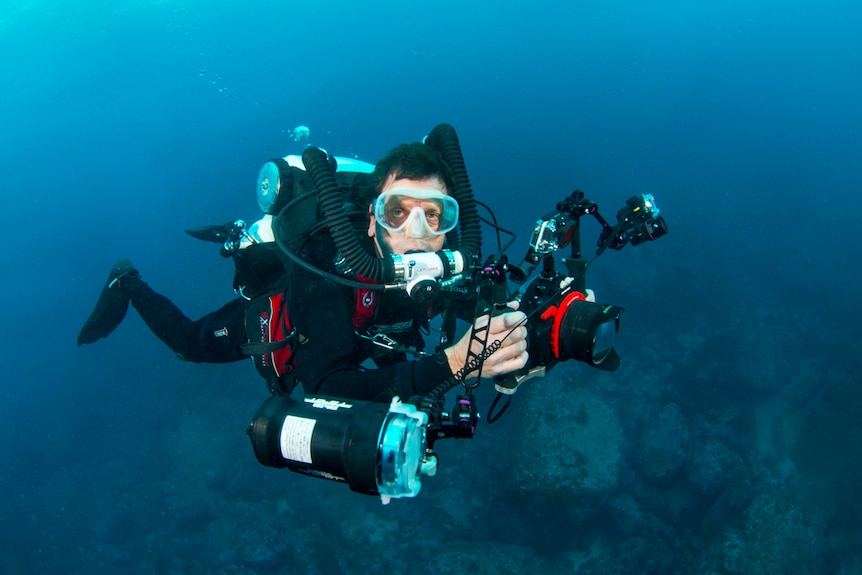 A man scuba diving with cameras