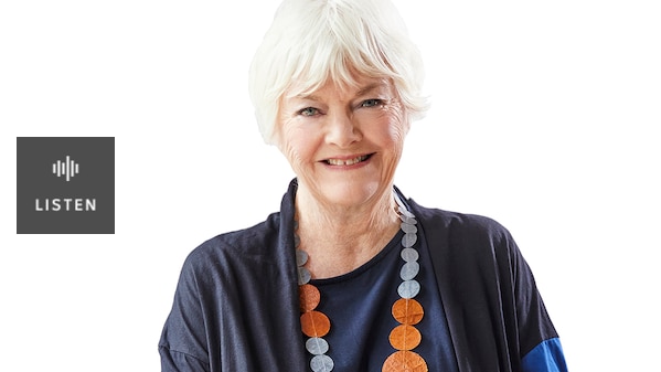 A woman with white hair sitting smiling. Has Audio.