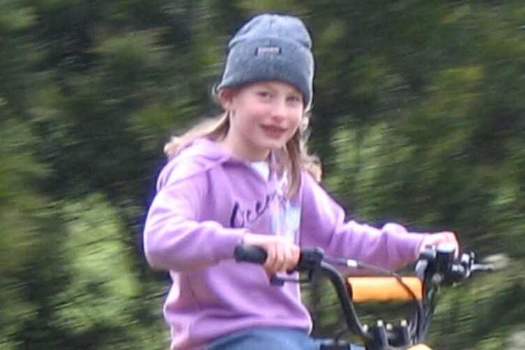 Chloe Myors riding a yellow quad bike wearing a hat.