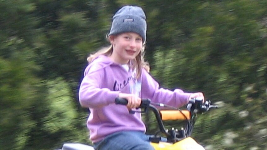 Chloe Myors riding a yellow quad bike wearing a hat.