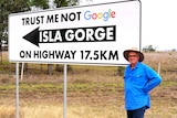 A farmer stands beside a sign that says, "Trust me not Google". 