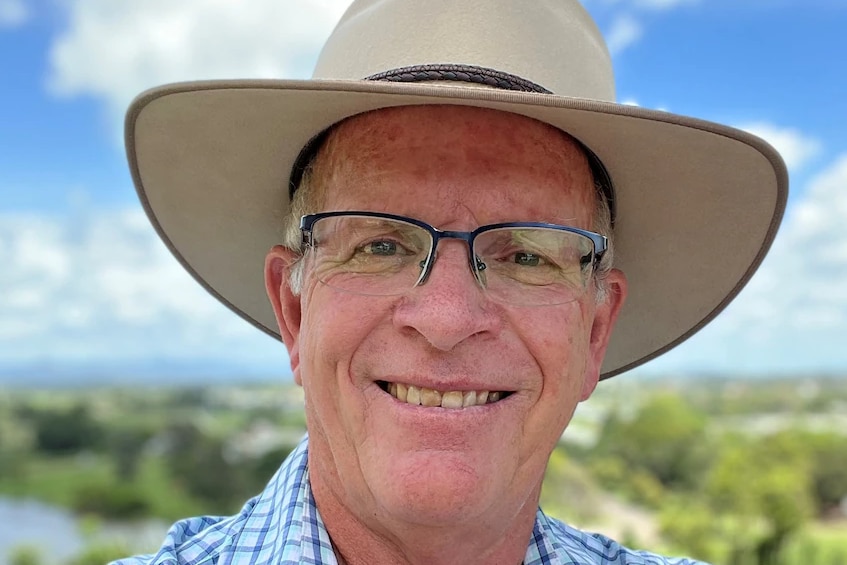 man wearing a hat smiling at the camera 