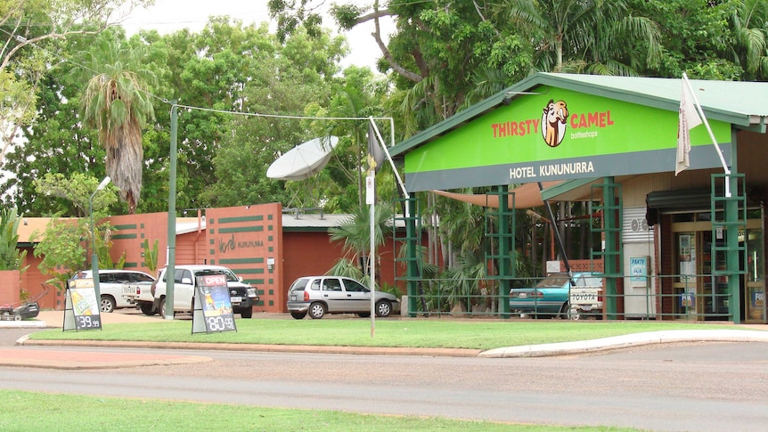 A Thirsty Camel bottle shop in Kununurra with cars parked outside.