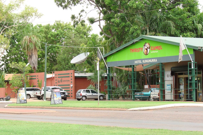 A Thirsty Camel bottle shop in Kununurra with cars parked outside.