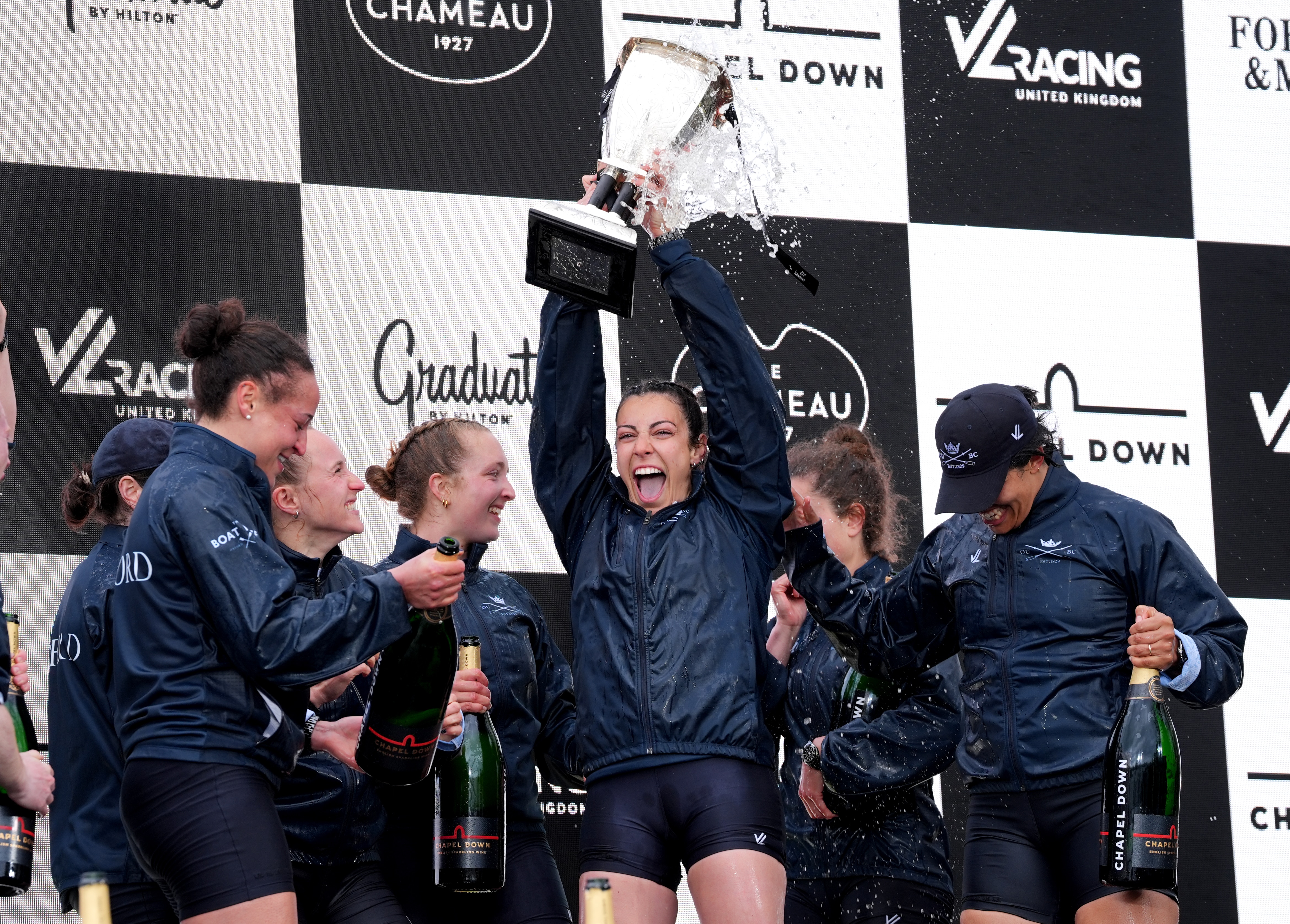 Oxford rowers celebrate with the trophy after winning the women's Boat Race.