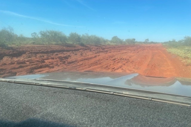 a red and muddy dirt road 