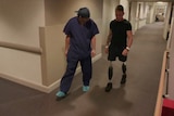 Darren Wilson walks on his prosthetic legs through a hospital corridor with Dr Munjed Al Muderis.