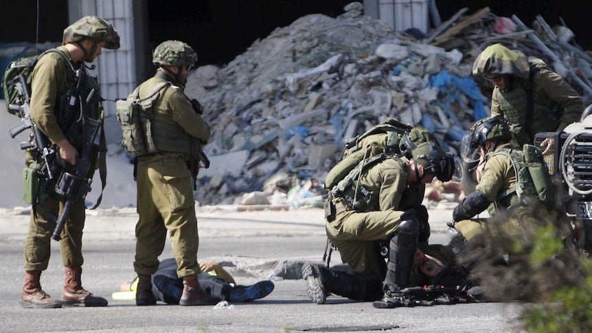 The body of a Palestinian who stabbed an Israeli soldier is seen on the ground