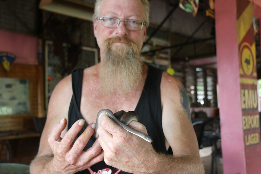 A man holds a snake