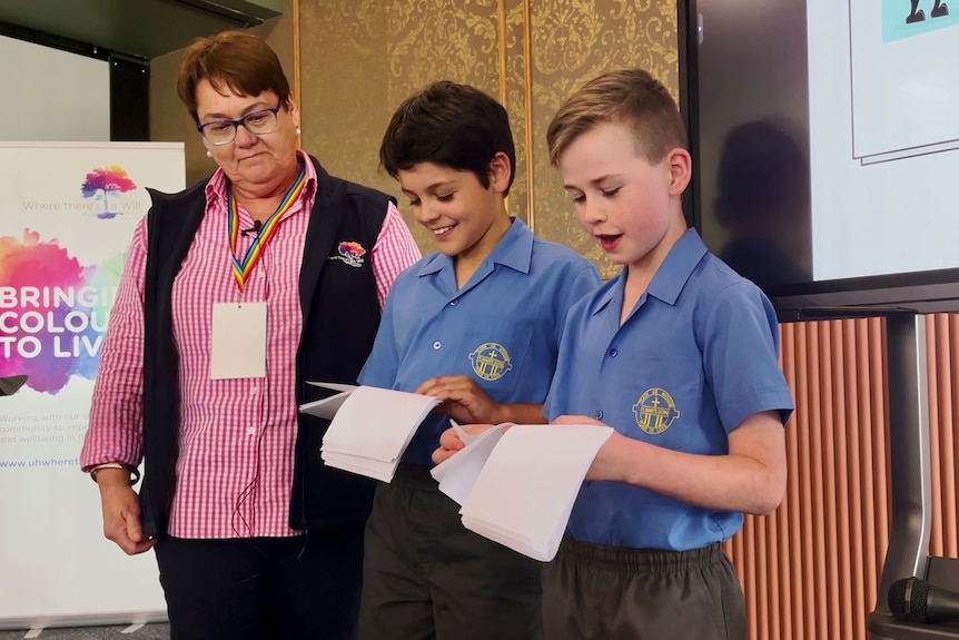 Two primary school students reading a speech.