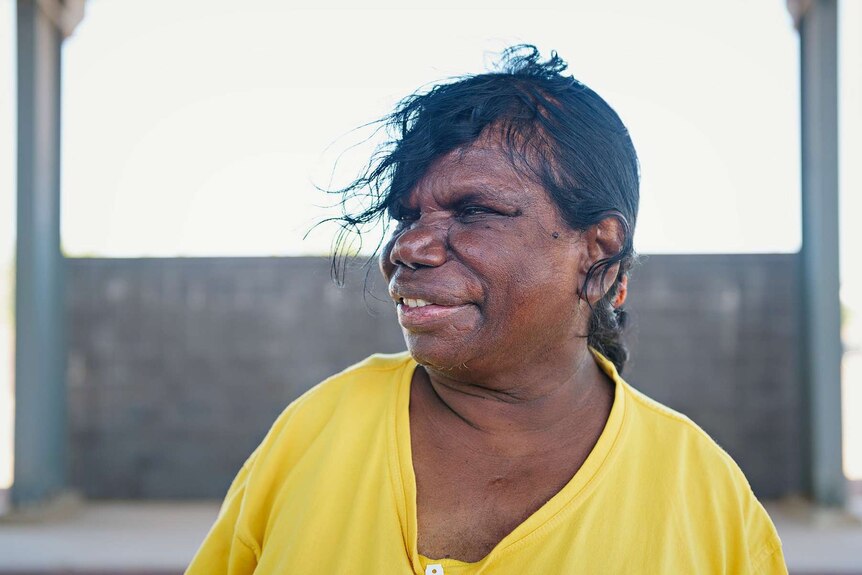 Kaye Woodroffe smiles while looking across the camera in a yellow shirt at the Darwin Correctional Centre.
