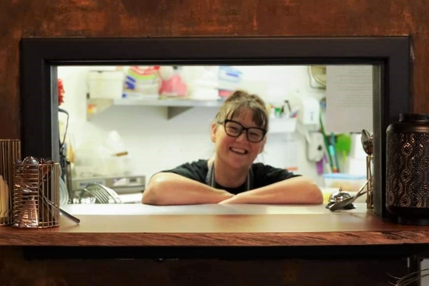 a woman leaning on a restaurant counter