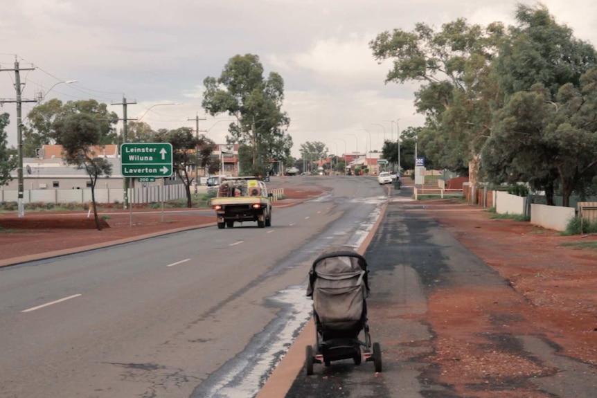 A ute drives into Leonora on the main road.