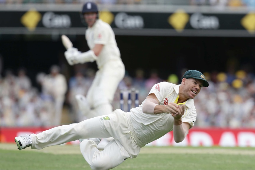Australia's David Warner dives for a catch to dismiss England's Jake Ball on day two at the Gabba.