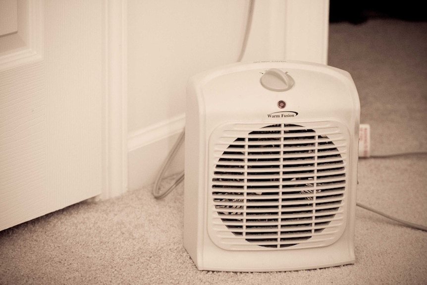 Close up of a blow heater on white carpet.