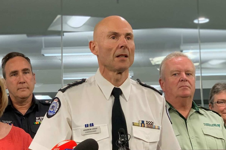 Victoria's Emergency Management Commissioner Andrew Crisp stands in front of a lectern.