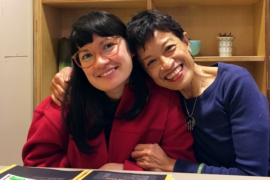 Two women sit at a restaurant table smiling for a story on grief anniversaries.