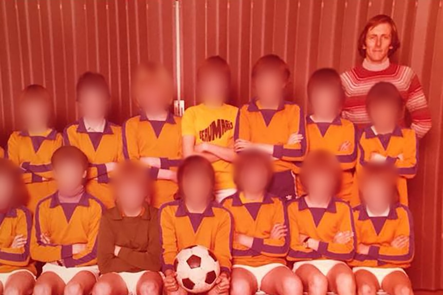 A an old colour photo of a boys soccer team with a male coach. The boys' faces are blurred.
