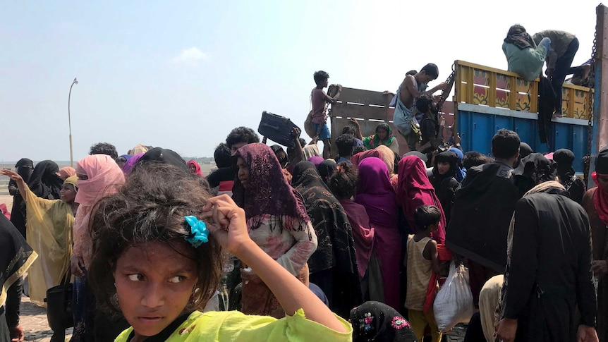 Rohingya refugees including children gather and climb onto a truck in Bangladesh.